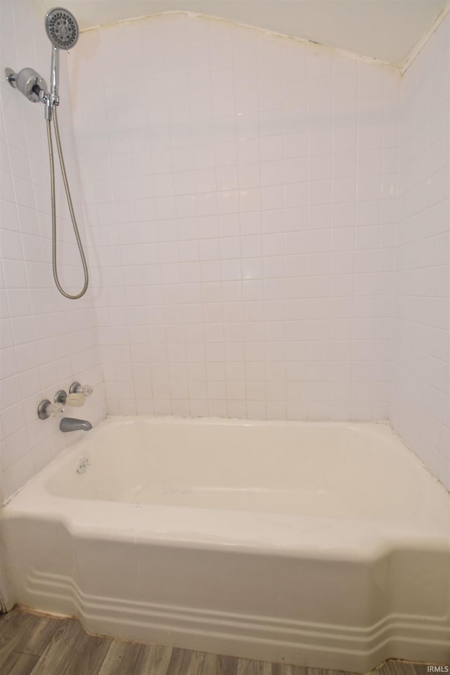 bathroom with tiled shower / bath and wood-type flooring