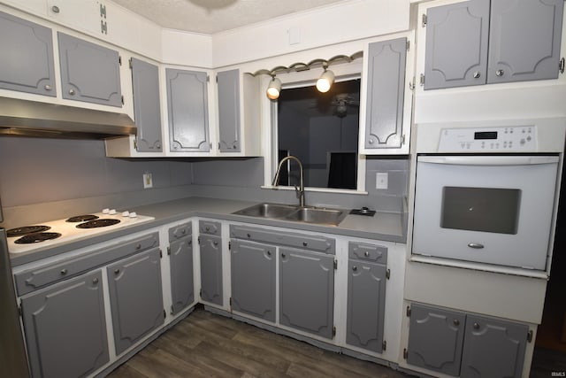 kitchen featuring sink, white appliances, and gray cabinetry