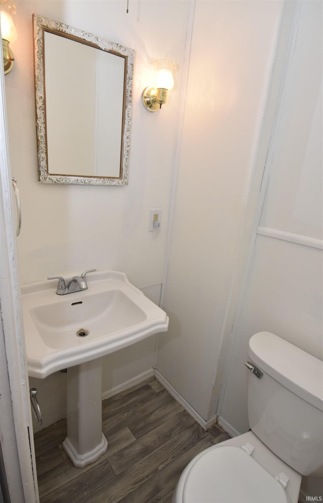 bathroom with hardwood / wood-style floors and toilet