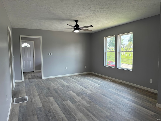 spare room featuring ceiling fan, wood-type flooring, and a textured ceiling