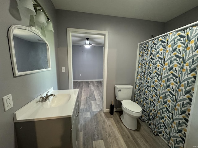 1302 21st St, Bedford, IN 47421 - full bathroom with toilet, wood finished floors, a shower with shower curtain, ceiling fan, and vanity
