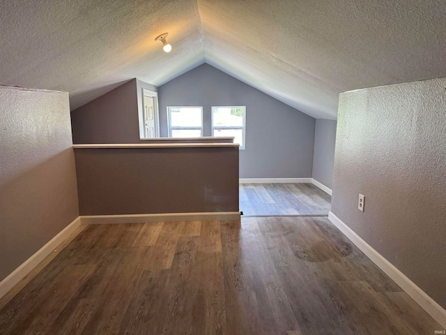 bonus room with vaulted ceiling, a textured ceiling, and wood-type flooring