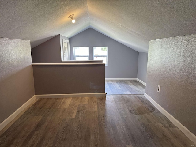 1302 21st St, Bedford, IN 47421 - bonus room with wood finished floors, a textured ceiling, vaulted ceiling, a textured wall, and baseboards