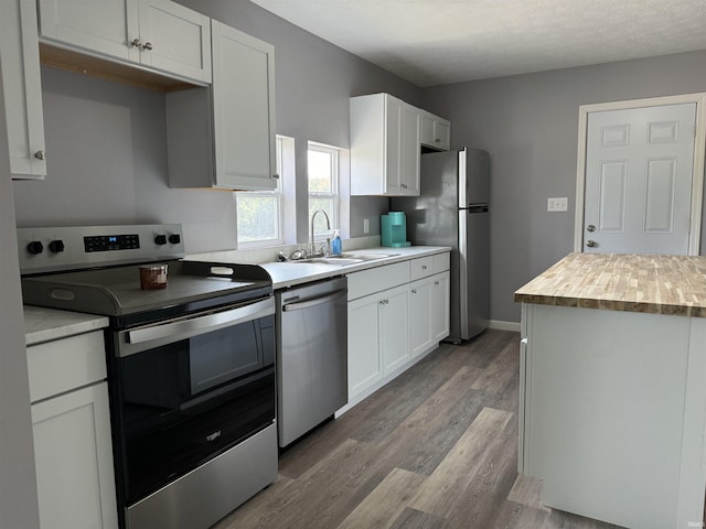 1302 21st St, Bedford, IN 47421 - kitchen with a sink, wood finished floors, butcher block counters, white cabinets, and appliances with stainless steel finishes