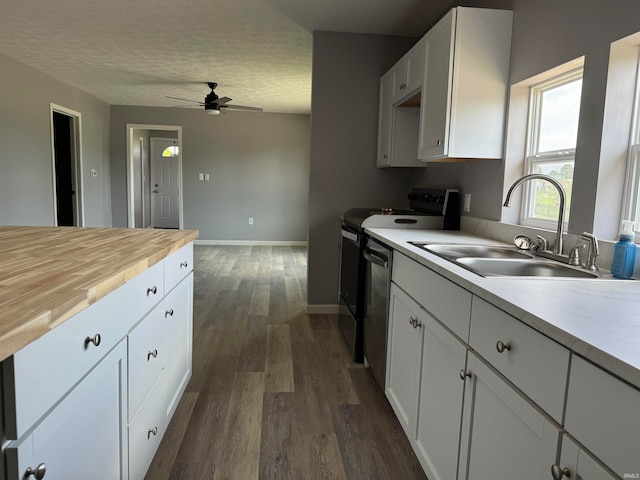 kitchen featuring stainless steel dishwasher, sink, dark wood-type flooring, white cabinets, and ceiling fan