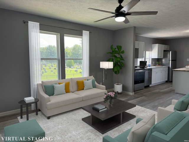 living room featuring a textured ceiling, ceiling fan, light hardwood / wood-style floors, and sink