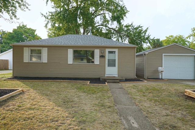 view of front of property with a garage, roof with shingles, a front lawn, and an outdoor structure