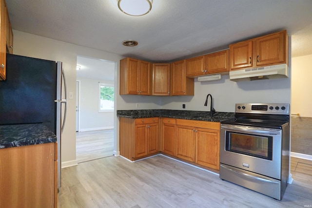 kitchen with light hardwood / wood-style flooring, sink, refrigerator, electric stove, and dark stone countertops