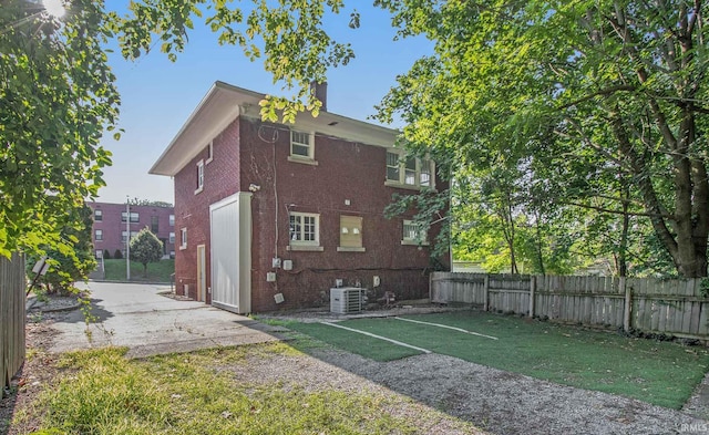 back of property with a lawn and cooling unit