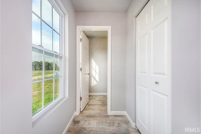 hallway with light hardwood / wood-style floors