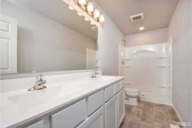 bathroom with vanity, walk in shower, and toilet