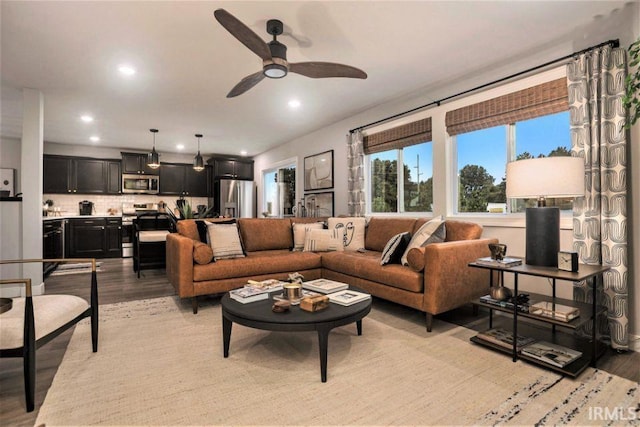 living room featuring ceiling fan and light hardwood / wood-style floors