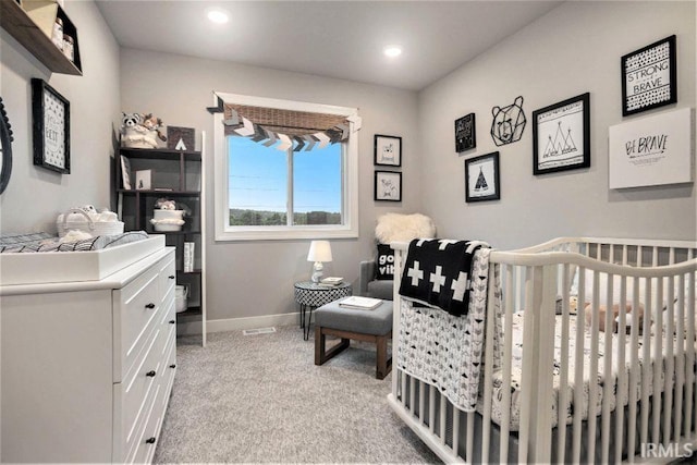 carpeted bedroom with a nursery area