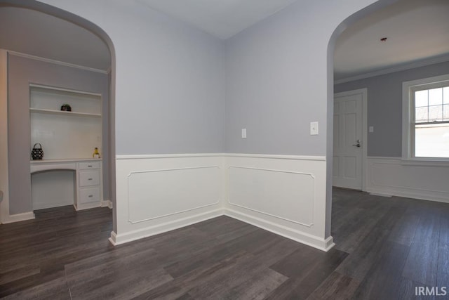 spare room featuring dark wood-type flooring and ornamental molding