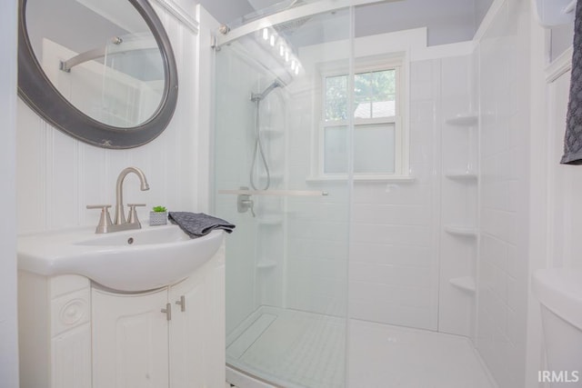 bathroom with toilet, vanity, and walk in shower