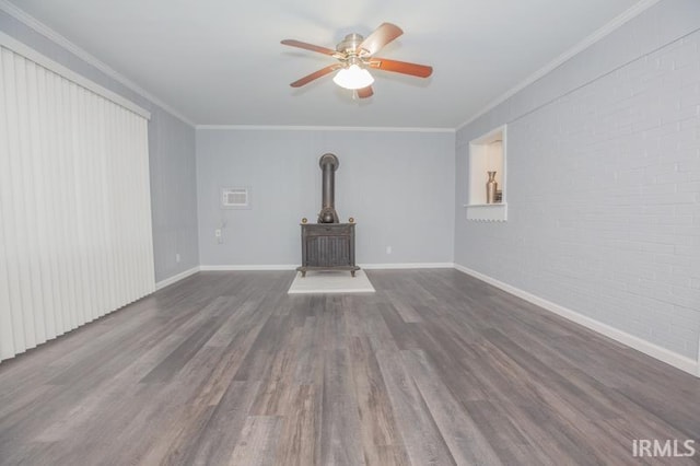 unfurnished living room featuring dark wood-style floors, a wood stove, crown molding, and brick wall