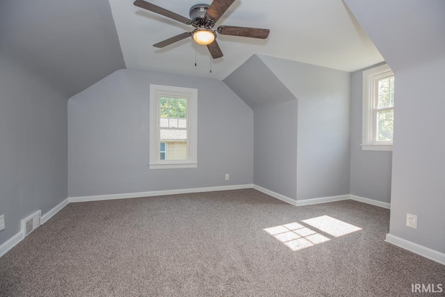 bonus room featuring carpet, visible vents, a ceiling fan, vaulted ceiling, and baseboards