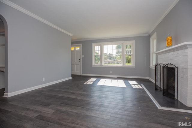 unfurnished living room with a brick fireplace, ornamental molding, and dark hardwood / wood-style flooring