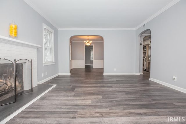 unfurnished living room featuring a fireplace, arched walkways, dark wood-style flooring, and ornamental molding