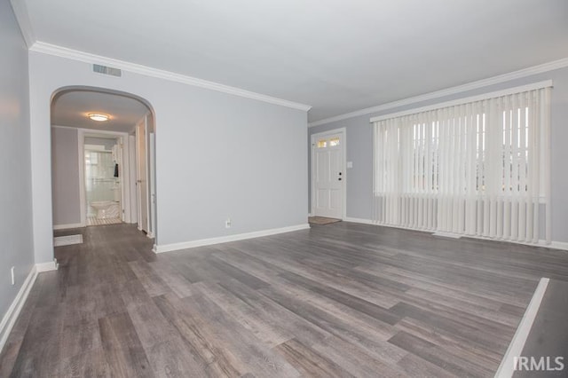 unfurnished living room featuring baseboards, visible vents, arched walkways, dark wood-style floors, and ornamental molding