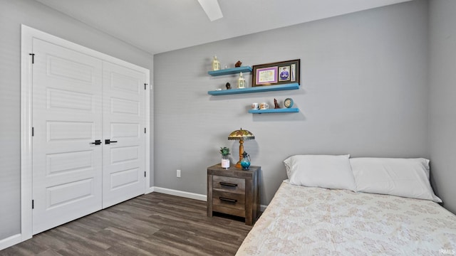 bedroom with a closet, wood finished floors, a ceiling fan, and baseboards