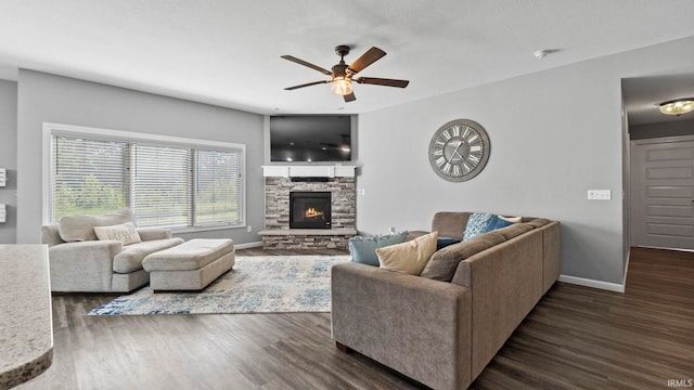 living area featuring dark wood-style floors, a fireplace, baseboards, and ceiling fan