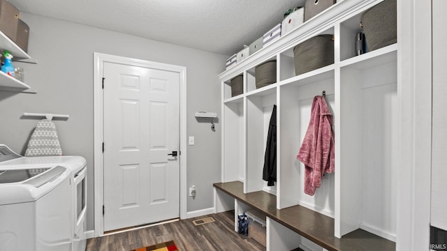 mudroom with a textured ceiling, dark wood-style flooring, visible vents, and washer and dryer