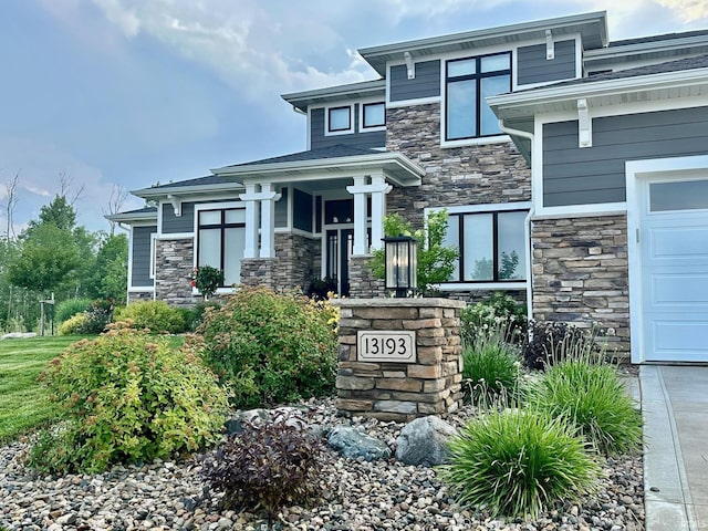 view of front of house with an attached garage and stone siding