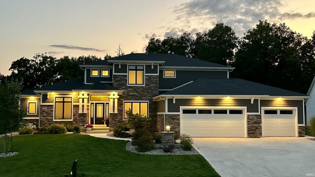 prairie-style home featuring a garage and a yard