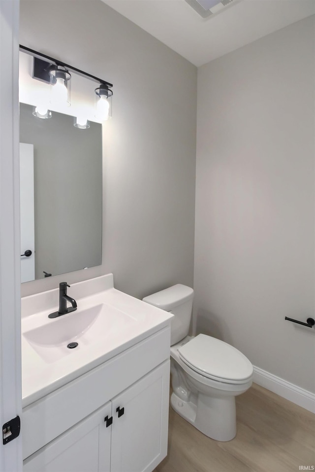 bathroom featuring hardwood / wood-style flooring, vanity, and toilet