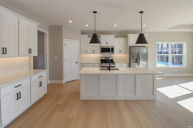 kitchen featuring pendant lighting, light hardwood / wood-style flooring, and appliances with stainless steel finishes