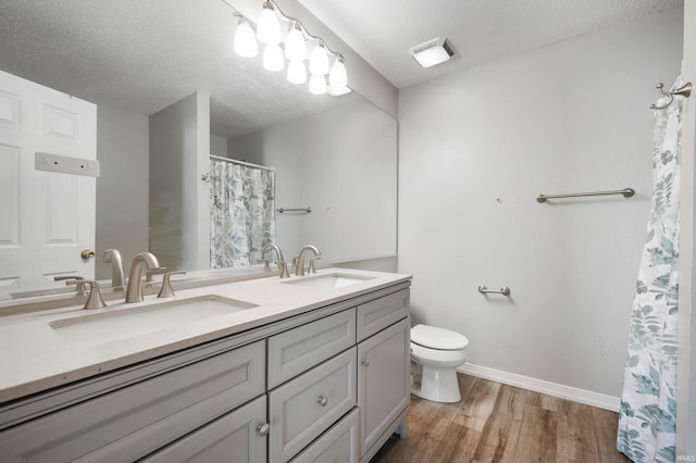 3128 Springwater Ct, Kokomo, IN 46902 - full bath with toilet, double vanity, wood finished floors, a textured ceiling, and baseboards