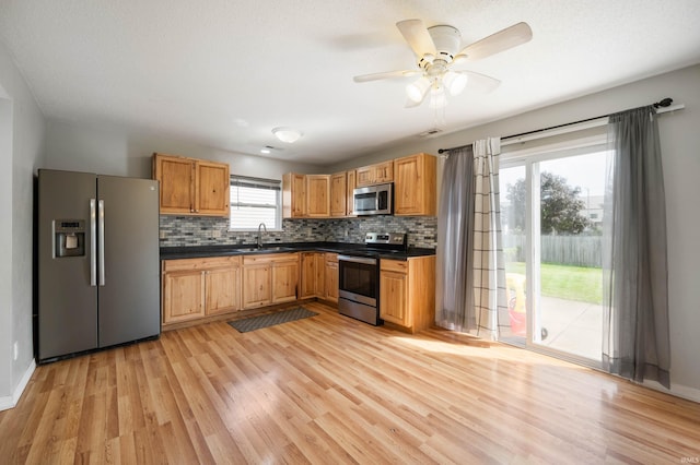 3128 Springwater Ct, Kokomo, IN 46902 - kitchen with stainless steel appliances, a sink, dark countertops, and light wood-style floors