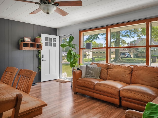 living area with a ceiling fan and wood finished floors