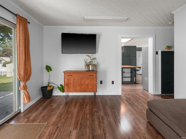 living room with baseboards, wood finished floors, and crown molding