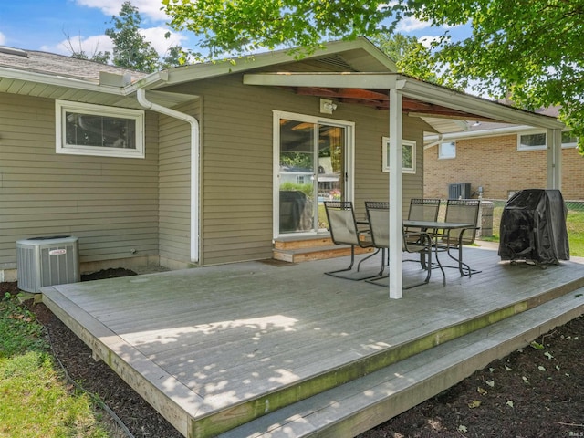 wooden terrace featuring outdoor dining space, area for grilling, and central AC