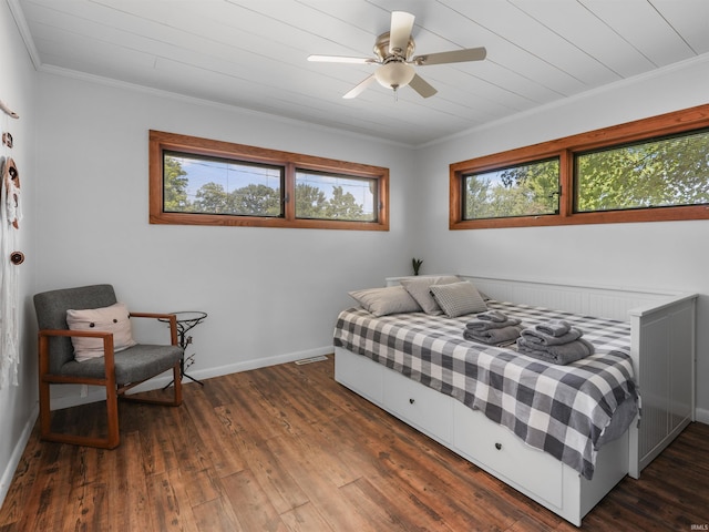 bedroom with dark wood-style floors, a ceiling fan, crown molding, and baseboards