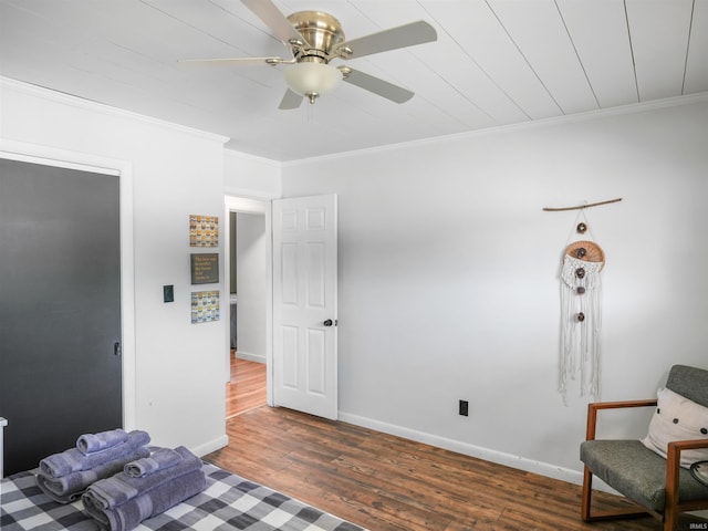 bedroom with baseboards, wood finished floors, a ceiling fan, and ornamental molding