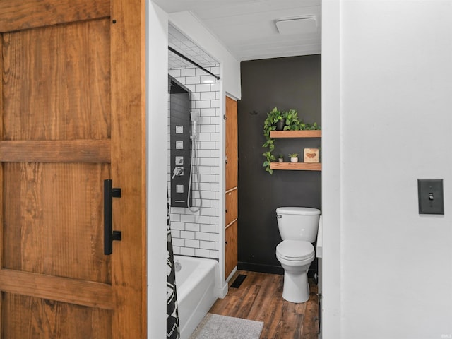 full bath with a bath, toilet, wood finished floors, and baseboards