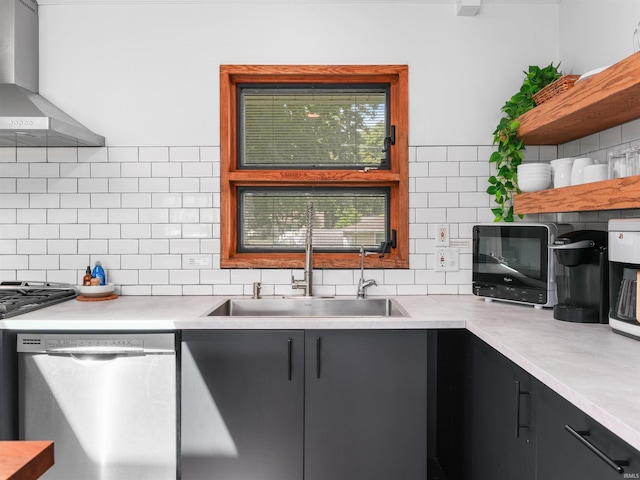 kitchen with a sink, open shelves, wall chimney range hood, stainless steel dishwasher, and light countertops