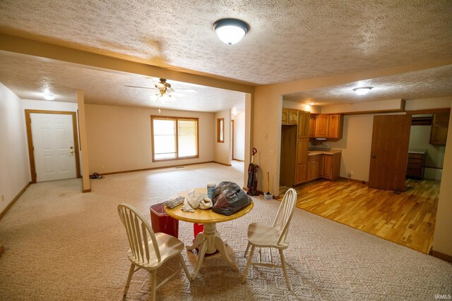 dining area with ceiling fan, a textured ceiling, and light carpet