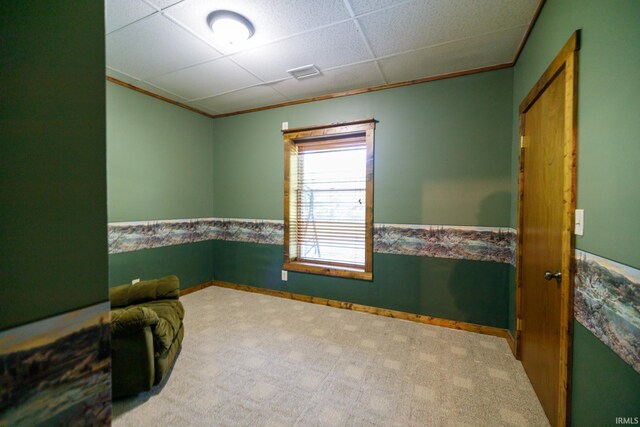 carpeted spare room featuring a paneled ceiling