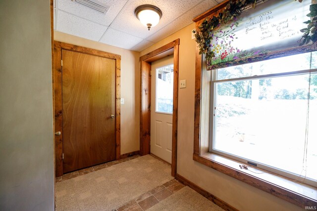 entryway featuring a drop ceiling and light tile patterned flooring