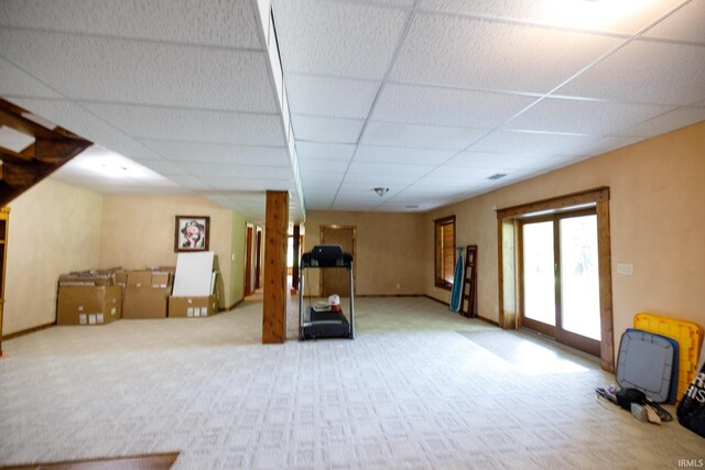 basement featuring carpet floors and a paneled ceiling