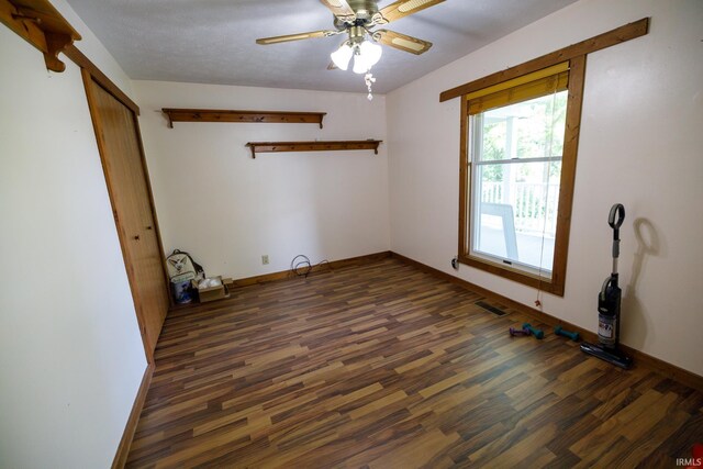 unfurnished room with ceiling fan and dark hardwood / wood-style flooring