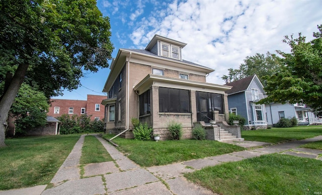 view of front of property with a front yard and a sunroom