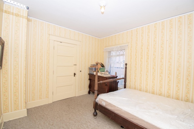 carpeted bedroom featuring baseboards and wallpapered walls