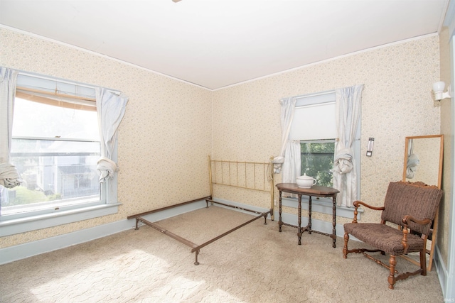 living area with baseboards, ornamental molding, light colored carpet, and wallpapered walls