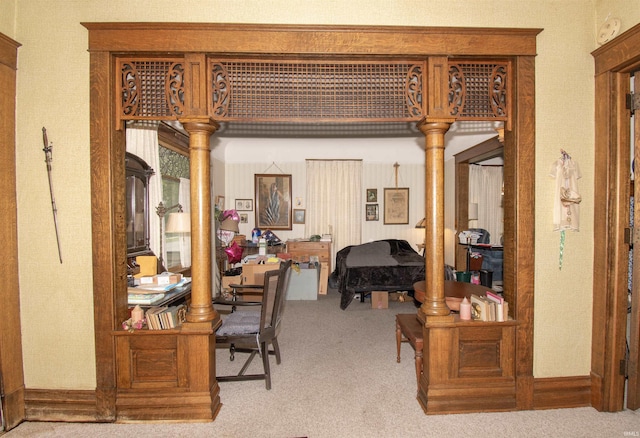 interior space with light carpet, baseboards, and ornate columns