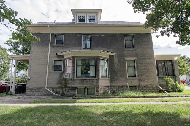 traditional style home featuring a front yard, brick siding, and cooling unit